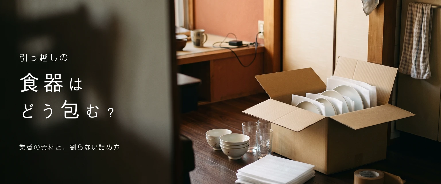 引っ越しの食器はどう包む？業者の資材と、割らない詰め方。白いシートで包んだ皿を立てて入れた段ボールの写真
