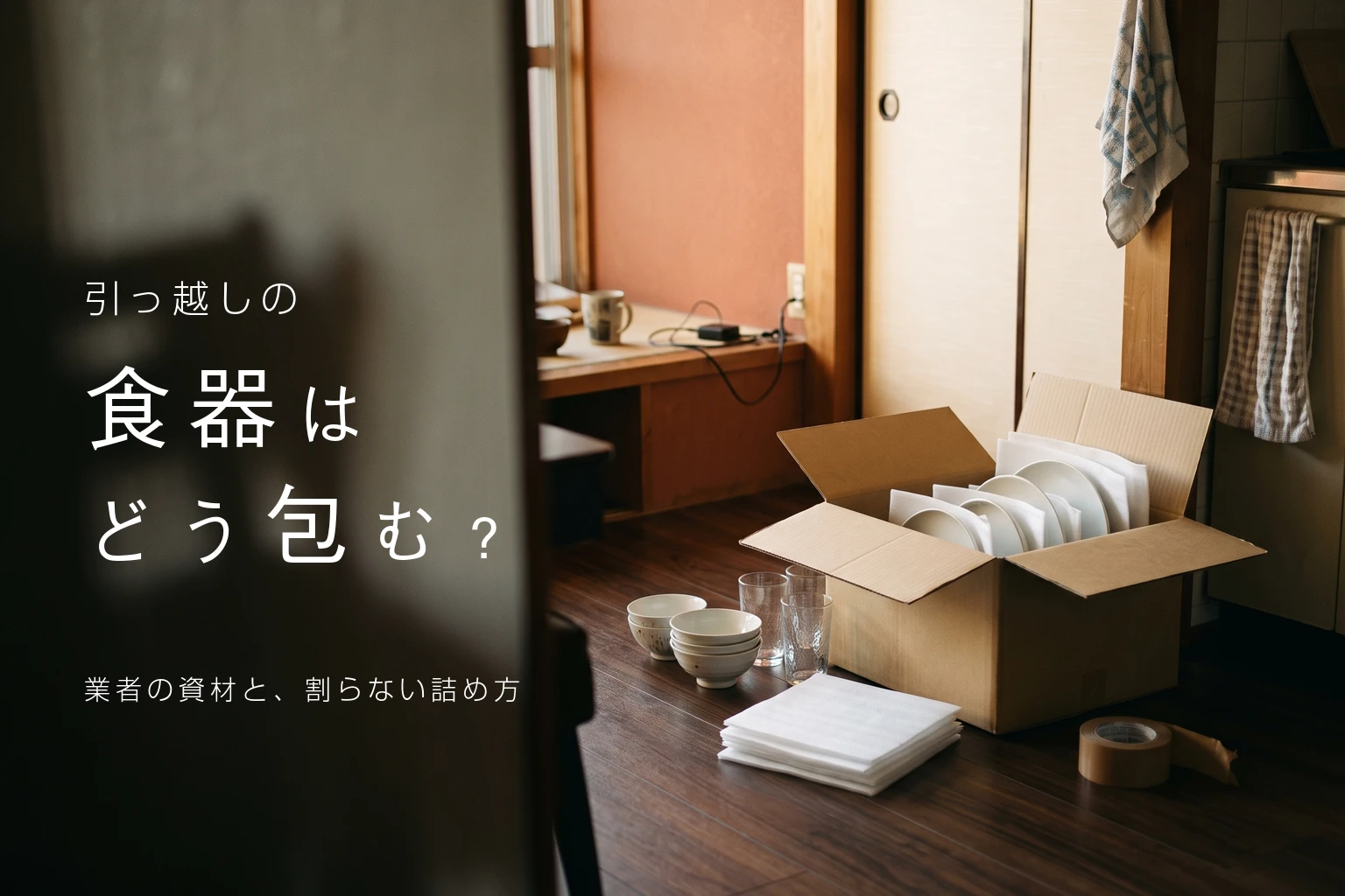 引っ越しの食器はどう包む？業者の資材と、割らない詰め方。白いシートで包んだ皿を立てて入れた段ボールの写真